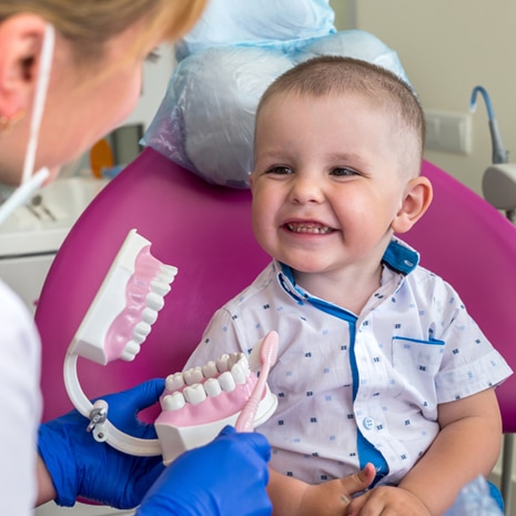 A toddler smiles at his dentist